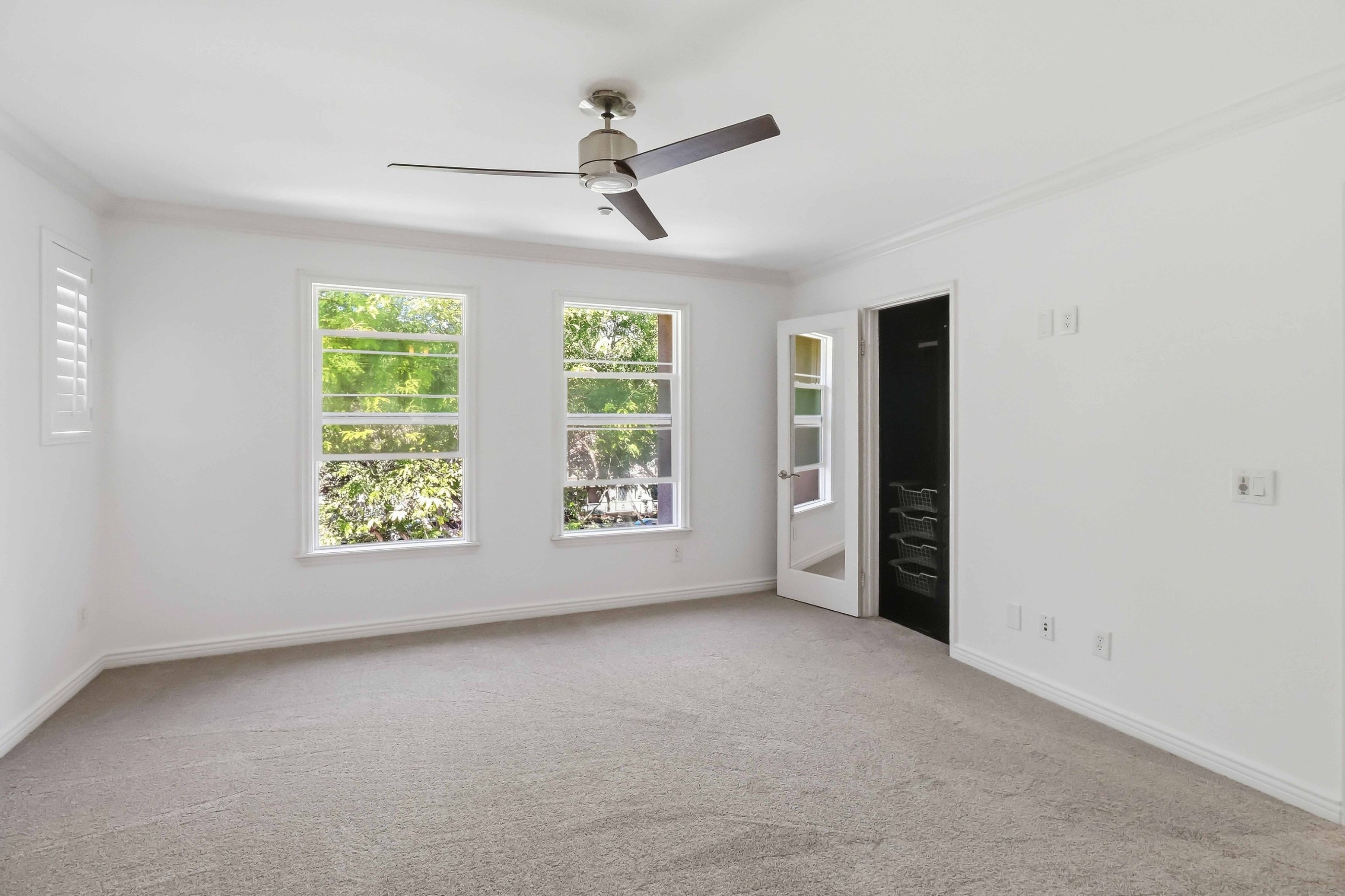 Secondary bedroom with plantation shutters and new carpet.