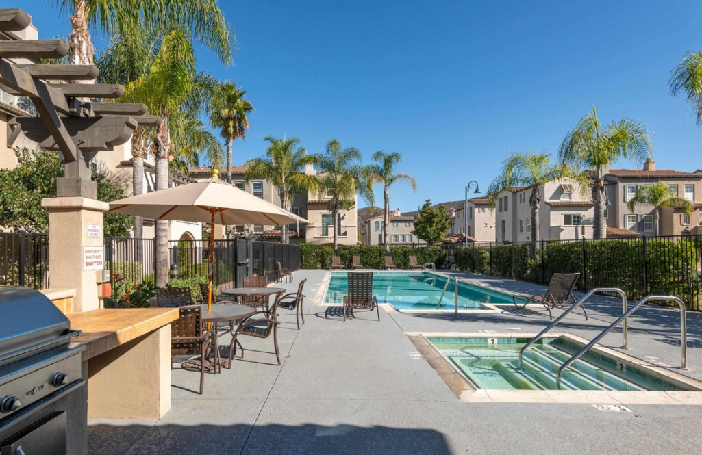 Community pool and BBQ area with lounge seating.