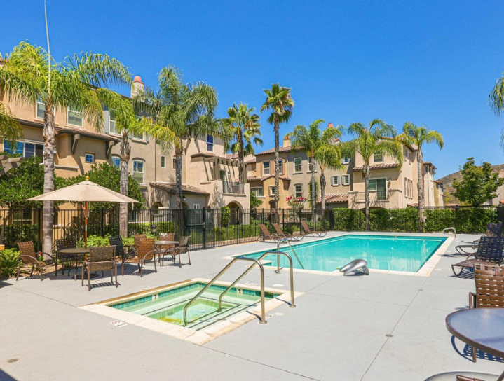 Community pool with palm trees and lounge seating inside the HOA.